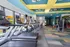 Bright, modern fitness center with rows of treadmills and exercise equipment, offering a vibrant space for workouts.