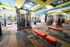 Modern fitness center with vibrant decor, state-of-the-art equipment, and bright natural lighting.