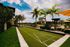 Inviting outdoor space featuring a bocce ball court surrounded by lush palm trees and vibrant green lawns, perfect for leisure and relaxation.