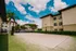 Inviting outdoor sand volleyball court surrounded by lush landscaping, with a backdrop of charming apartment buildings under a beautiful blue sky.
