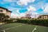 Inviting outdoor basketball court with scenic apartment views under a vibrant blue sky.