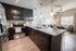 Elegant open-concept kitchen with granite countertops, modern appliances, and a cozy living area with natural light.
