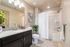 Elegant bathroom with modern vanity, granite countertop, cozy lighting, and stylish decor enhancing a serene atmosphere.