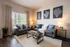 Inviting living room with sleek gray sofas, elegant coastal artwork, and warm accent lighting, perfect for cozy evenings.
