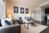 Inviting living room with modern gray sofas, plush pillows, elegant wall art, and a chic coffee table in a bright, airy space.