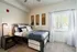 Bright and cozy bedroom with modern decor, plush bedding, and a large window offering natural light.