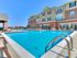 Inviting apartment complex with a sparkling pool and comfortable lounge chairs, perfect for relaxation and leisure.