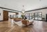 Luxurious living area featuring elegant brown sofas, large windows with natural light, and stylish wooden flooring.
