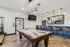 Chic entertainment room featuring a sleek pool table, elegant seating at a stylish bar, and ambient pendant lighting.