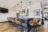 Elegant kitchen bar area featuring stylish pendant lighting, sleek countertop, and plush leather stools on rich wood flooring.