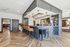 Chic contemporary bar area with stylish seating, modern lighting, and herringbone wood flooring in a welcoming apartment space.