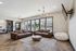 Inviting living room with chic leather sofas, a modern round wooden coffee table, and large windows offering ample natural light.