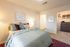 Inviting bedroom with elegant decor and soft lighting, featuring a cozy bed, stylish artwork, and a spacious closet.