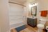 Inviting bathroom with modern vanity, elegant mirror, and sleek fixtures complementing the warm wood flooring.