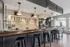 Elegant modern kitchen with stylish bar seating, sleek countertops, and contemporary pendant lighting.
