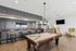 Chic and inviting recreation room with a stylish billiards table, elegant bar seating, and cozy lounge area, perfect for entertaining.