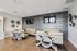 Modern seating area with chic wooden tables, plush beige benches, and decorative wall fans creating a cozy ambiance.