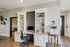 Chic office space with built-in white shelving, a modern computer setup, and sleek decor for a productive work environment.