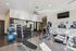Modern fitness center equipped with treadmills, ellipticals, free weights, and exercise balls, featuring sleek design and spacious interior.
