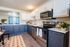 Chic and modern kitchen with sleek stainless steel appliances, stylish navy and white cabinetry, and bright natural light filtering through blue curtains.