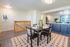 Bright and inviting open-concept dining area with elegant table setting, adjacent to a modern kitchen featuring sleek blue cabinetry.