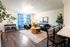 Inviting living room with elegant decor, featuring a cozy seating area, vibrant blue curtains, and modern furnishings for a stylish ambiance.