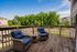 Charming outdoor deck with cozy wicker chairs and lush greenery views, perfect for relaxation.