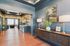 Elegant hallway featuring rich wooden flooring, tasteful wall art, and stylish blue cabinetry leading to a cozy living area.