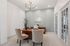 Elegant home office with a warm wood desk, comfortable beige chairs, and a stylish chandelier, creating a sophisticated workspace.