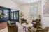 Elegant living area with plush armchairs, modern decor, and abundant natural light from large windows.