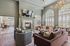 Elegant living room with contemporary furniture, a chic fireplace, large windows with shutters, and modern decor.