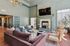 Elegant living room with plush velvet sofa, cozy armchairs, and a modern fireplace under a chic chandelier, creating an inviting atmosphere.
