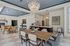 Elegantly designed open-plan living area with stylish dining room, modern kitchen, and chic lighting fixtures.