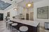 Elegant kitchen design with a spacious marble island, modern pendant lights, and plush bar stools, perfect for entertaining.