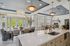 Luxurious open-concept dining and kitchen area with elegant lighting fixtures, a large island, and scenic outdoor views.