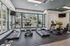 Bright fitness center with modern cardio equipment, expansive windows, and pool view.