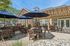 Inviting outdoor patio area with stylish wooden furniture and large umbrellas perfect for relaxation and social gatherings.