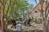 Charming outdoor patio with cozy seating, fire pit, and lush greenery, perfect for relaxation and social gatherings.