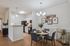 Chic open-plan kitchen and dining area with modern lighting, vibrant wall art, and elegant decor.