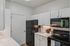 Modern kitchen with sleek black appliances, elegant white cabinetry, and polished countertops, exuding a contemporary and inviting atmosphere.