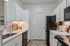 Charming kitchen with elegant white cabinetry, modern appliances, and cozy lighting creating a warm and inviting atmosphere.
