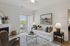 Bright and cozy living room with elegant decor, featuring a plush sofa, stylish coffee table, and access to a serene balcony through glass doors.