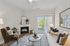 Inviting living room with cozy seating, a stylish fireplace, and abundant natural light through large sliding doors, ideal for relaxation and entertaining.