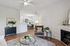 Charming open-concept living area with elegant armchair, cozy fireplace, and sophisticated decor blending seamlessly into a stylish dining space.