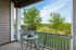 Charming patio with bistro table overlooking lush greenery, perfect for tranquil outdoor relaxation.