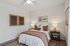 Cozy bedroom with elegant decor, featuring a plush bed, stylish nightstands, and artistic wall art, perfect for relaxation.
