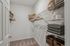 Spacious walk-in closet with organized wire shelving, cozy carpet, and ample storage baskets.