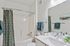 Bright and modern bathroom with elegant fixtures, featuring a sleek vanity, stylish ceramic sink, and a cozy bathtub with a chic patterned curtain.