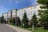 Charming apartment building with modern brick and siding exterior, surrounded by lush greenery and convenient future resident parking.
