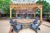 Charming patio with a wooden pergola and cozy fire pit surrounded by Adirondack chairs, perfect for outdoor relaxation and entertaining.